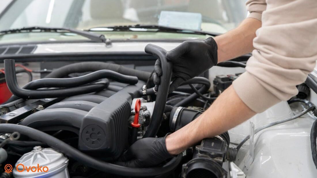 Mecanic verificând furtunurile și sistemul de ventilație al unui motor diesel